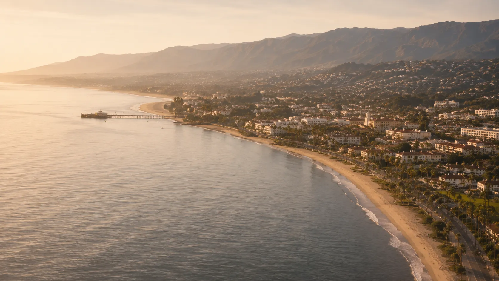 The Santa Barbara waterfront from the air at golden hour, with the pier and the beachfront below